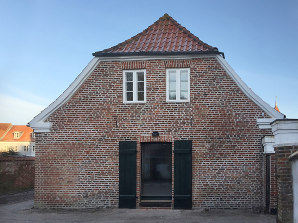 Eksempel på forsatsdør placeret på bagsiden af døråbningen ved en revledør (Bispegade 6, Ribe). Revledøren er nænsomt bevaret, kan uden problem stå åben og bidrager med karakter og autenticitet til bygningen. Den nye dør åbner indad og er energirigtig i forhold til nutidige krav.